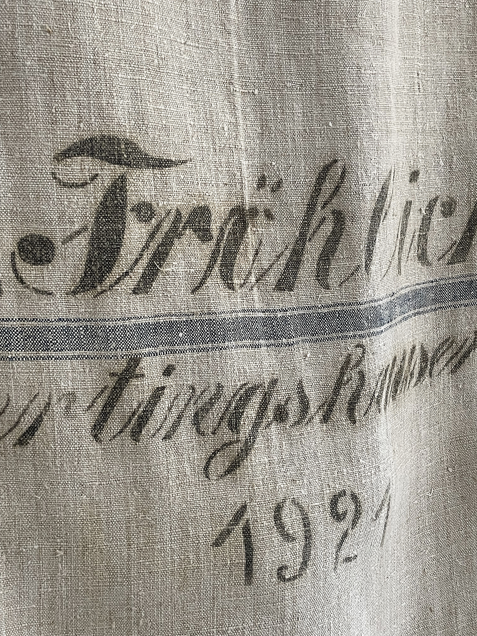 Detailansicht eines antiken Tischtuchs mit dem Schriftzug Trächtig und dem Jahr 1921