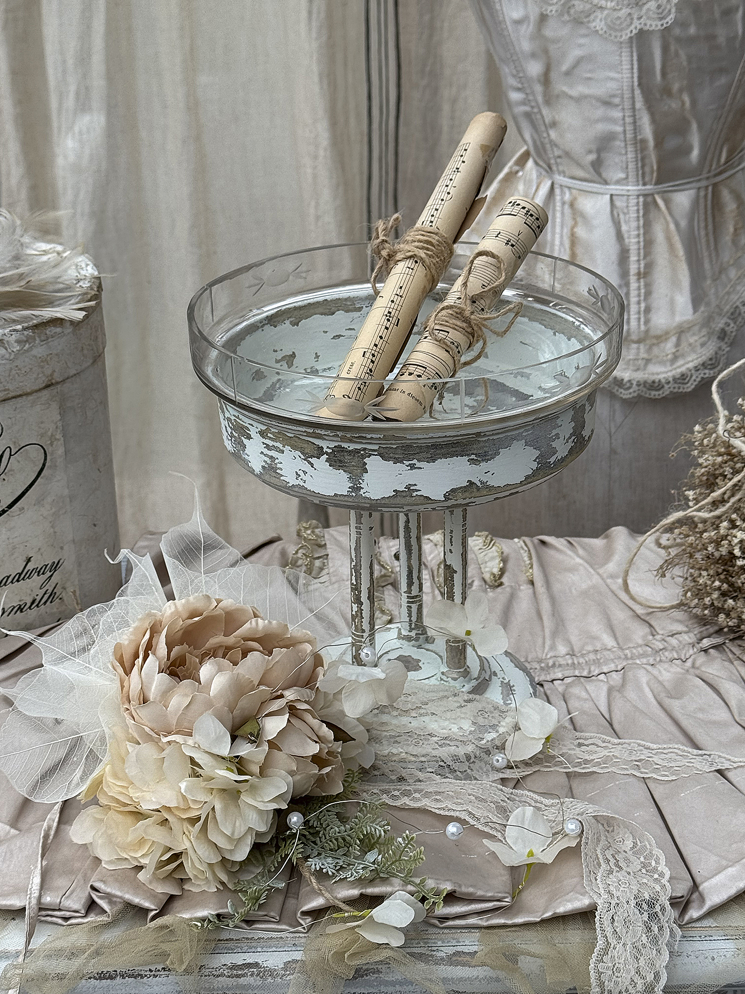 Vintage Dekoration mit Glasschale, Rollen und romantischem Blumenbouquet