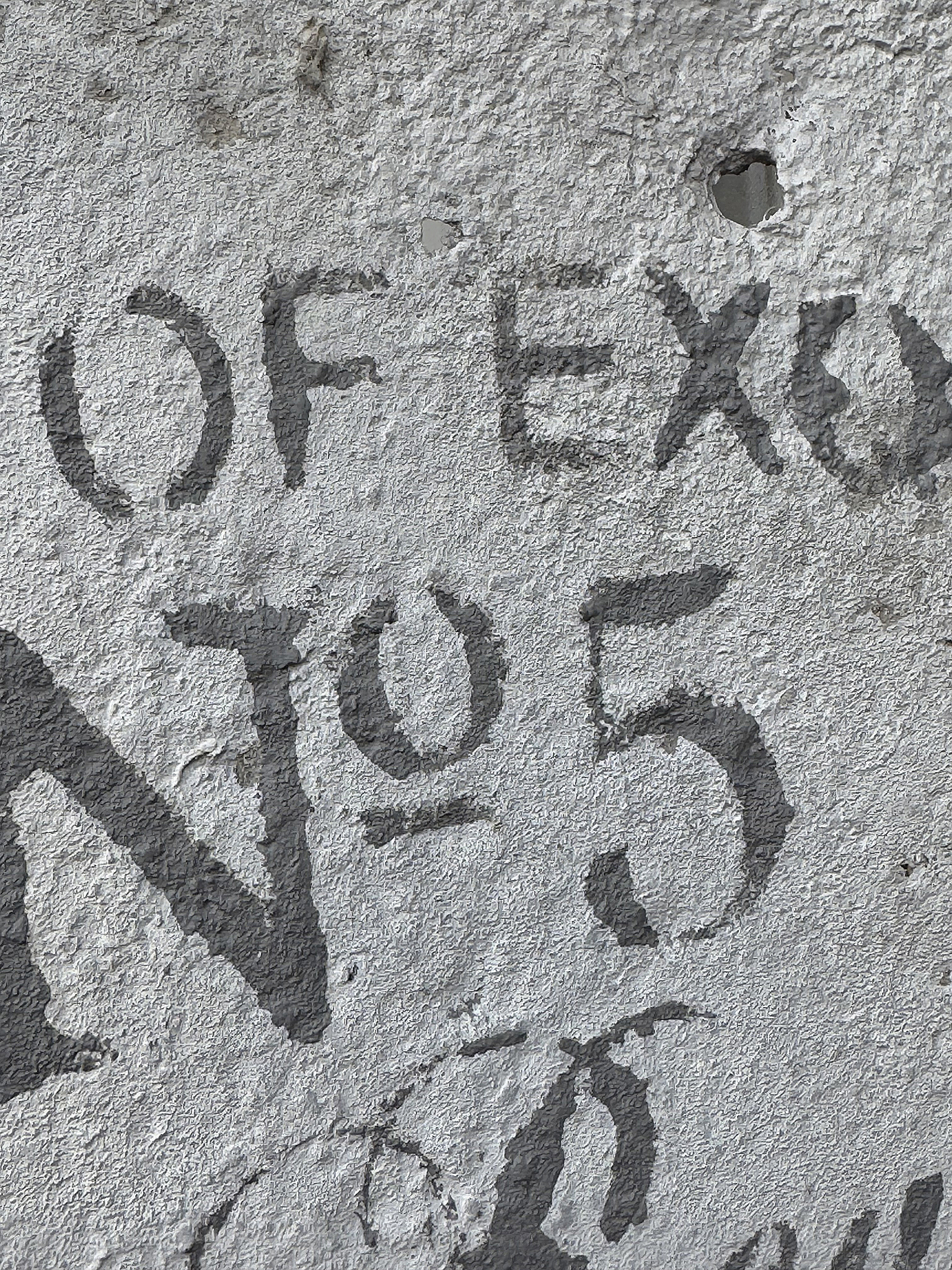 Nahaufnahme einer Wand mit handgeschriebener Inschrift von "OF EX NO 5"