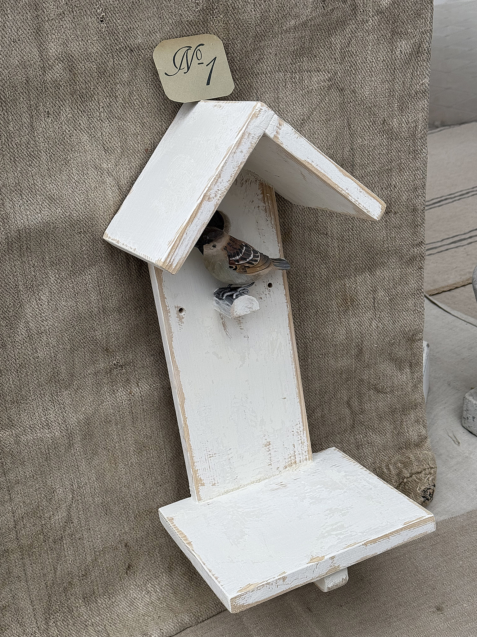 Vogelhaus im rustikalen Design mit einer kleinen Vogelfigur