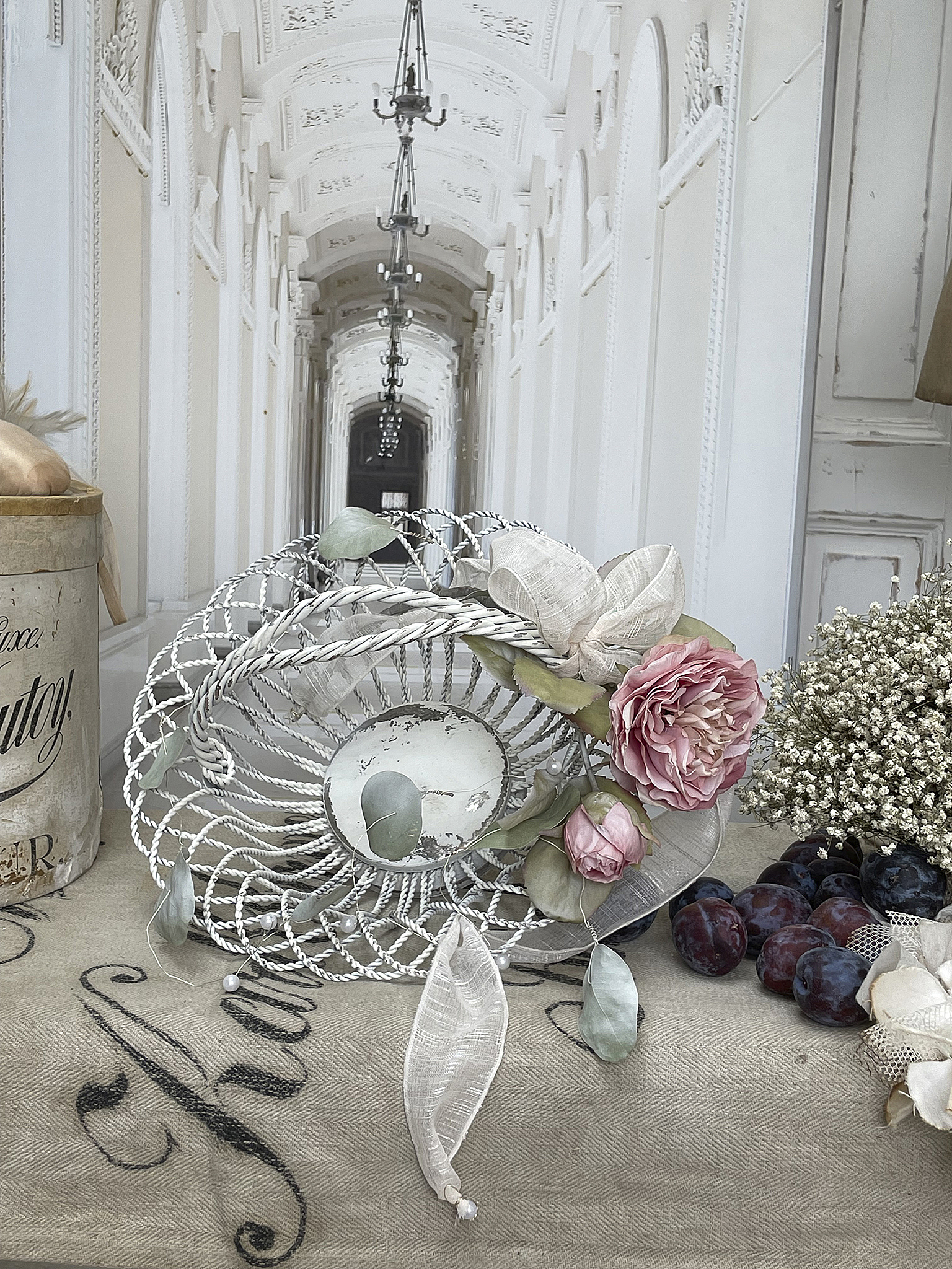 Dekorative Schale auf Tisch mit rosa Rosen, Beeren und Frühlingsblumen in einem eleganten Ambiente