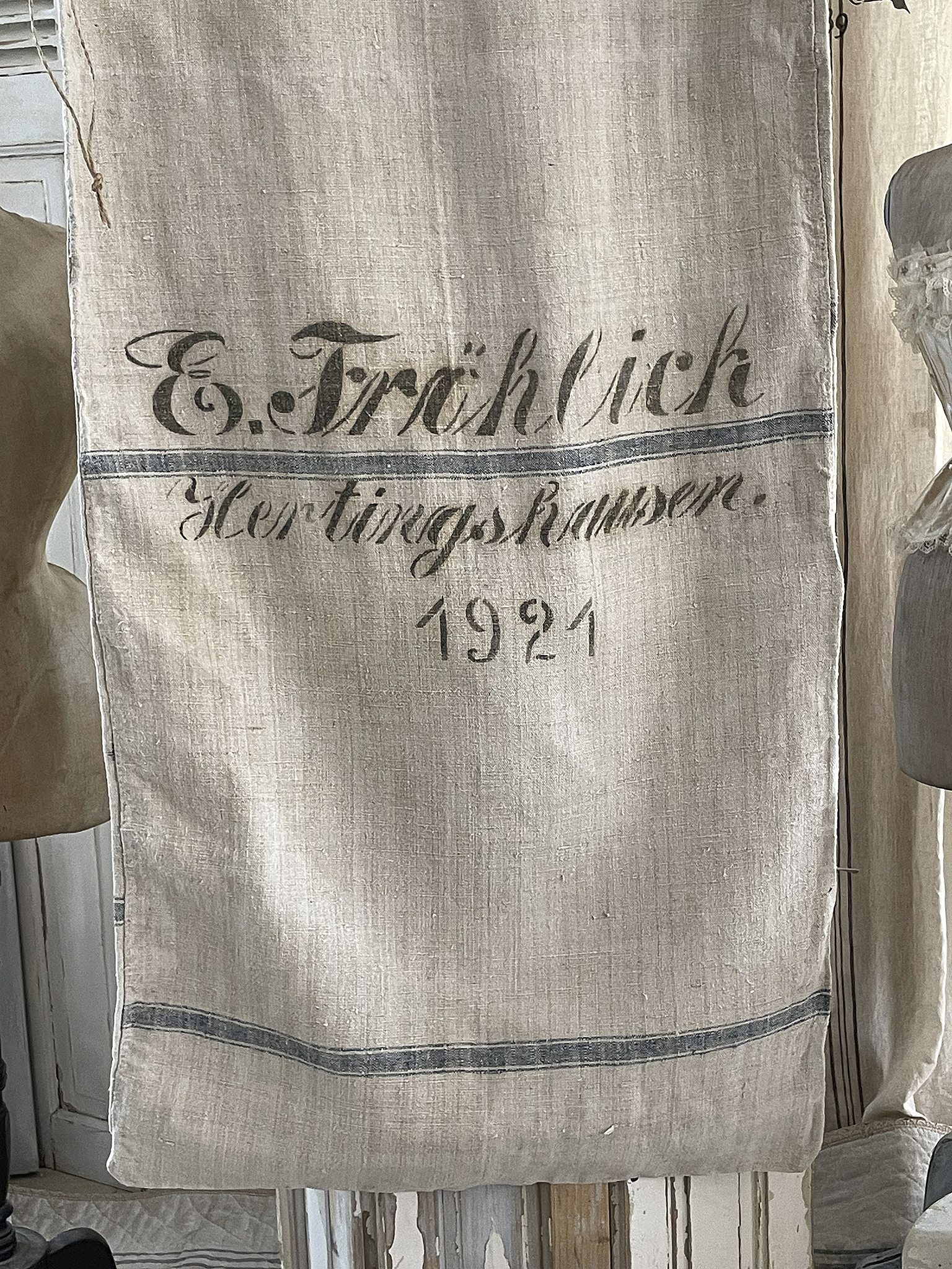 Detailaufnahme eines Vintage-Leinenbeutels mit dem Aufdruck E. Trählich, Hertingshausen, aus dem Jahr 1921.