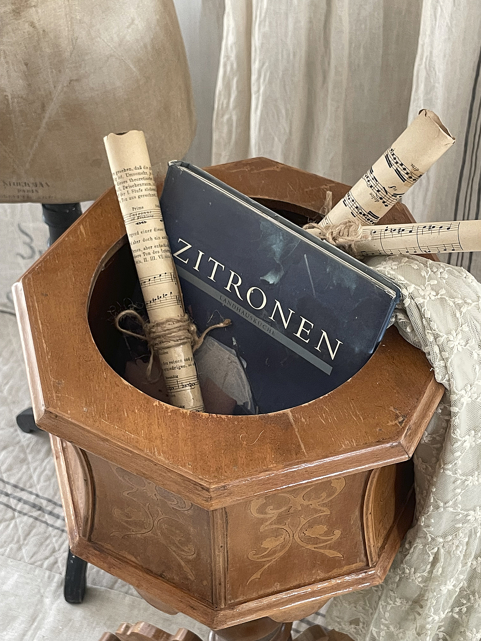 Ein stilvoller Holzbehälter mit dem Buch 'Zitronen' und Notenrollen.